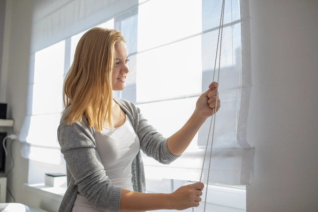 BelleVue Window Shades in Tucson A young woman folding BelleVue shades in Tucson
