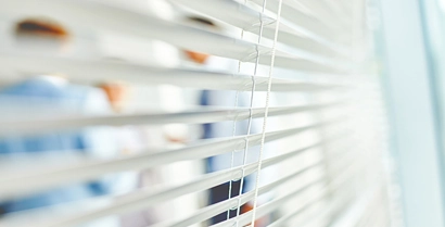Office workers behind window blinds in Tucson