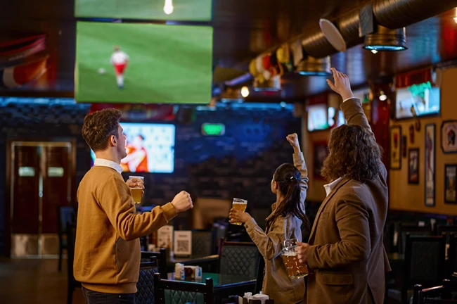People at a restaurant watching a video wall