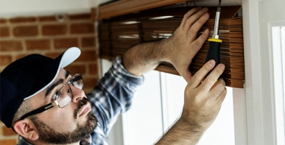 Technician Installing Window Blinds in Tucson Techinician installing window blinds in a home in Tucson