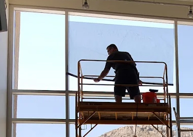Technician installing a house window tint film Certified installer applying residential window film during a home window tint installation in Tucson
