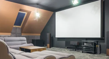 Home theater setup with screen, surround speakers and theater seating